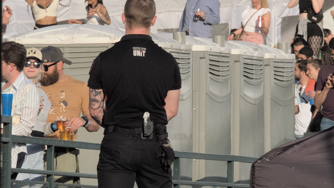 Armed security officer standing watch at a busy venue